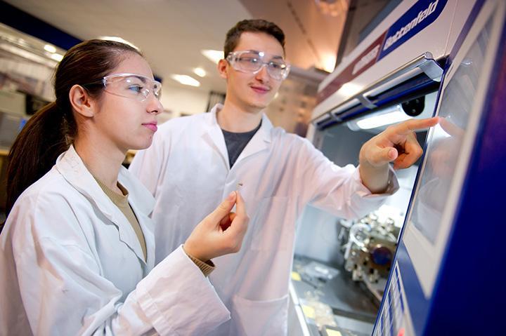 A landscape image of a female and male technician carrying out work in a lab