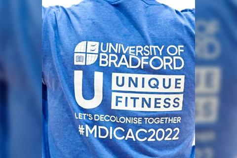 Close up of a T-shirt from Team Bradford day with the text University of Bradford, Unique Fitness, Let's Decolonise Together, #MDICAC2022.