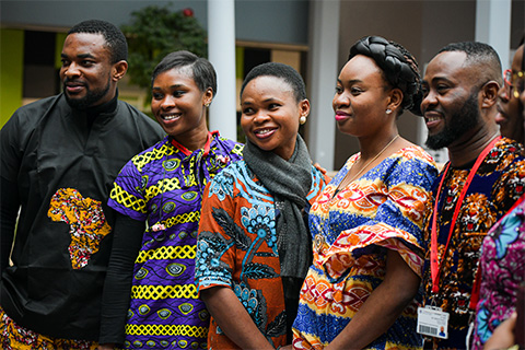 A group of black students smiling and posing for a photograph at a University event.