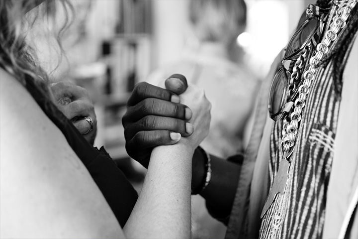 Two hands of people from other cultures, clasped in solidarity.