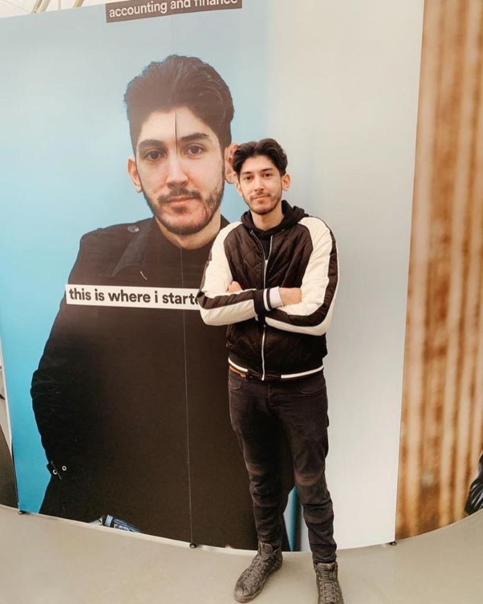 Osman Ehtsham, 2020 BSc Accounting, Finance and Economics alumnus, standing in front of a poster of himself.