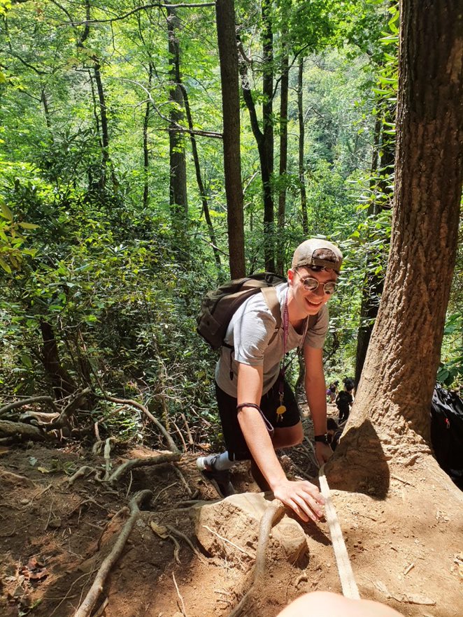 A student in the USA climbing a hill in a forest