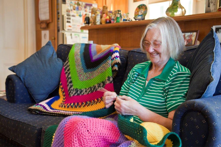 Elderly person sitting on sofa knitting - photo copyright by Cathy Greenblat