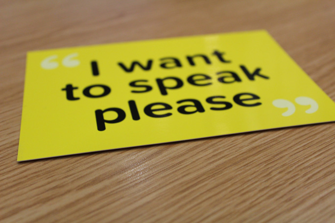 A yellow sign with black text that says 'I want to speak please'.