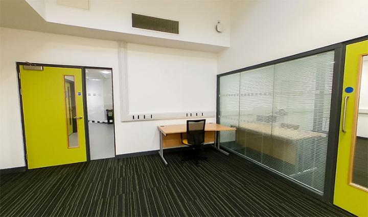 Image of the DHEZ hot desk space with a desk and meeting room