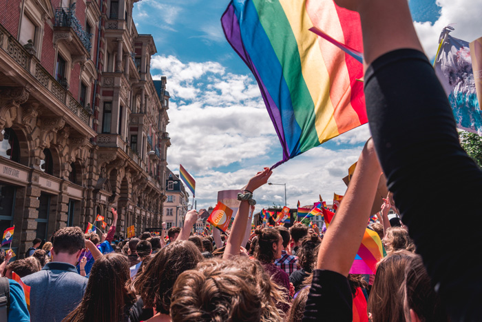 Crowd waving rainbow flags at an LGBT pride parade.
