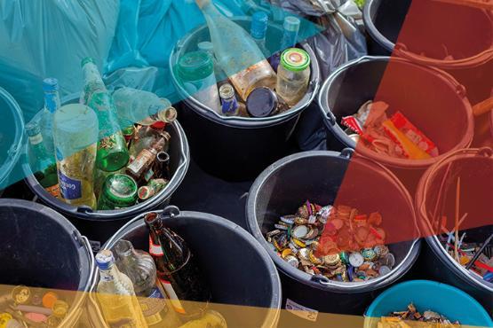 Differrent types of recycling such as glass bottle, cans and cardboard separated into different buckets.