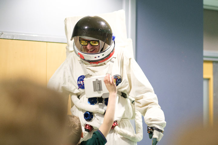 A man on stilts wearing an astronaut costume