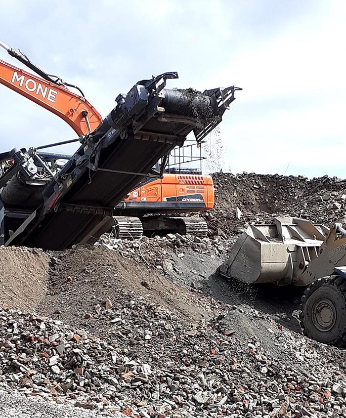 A site where rubble is being processed by heavy machinery