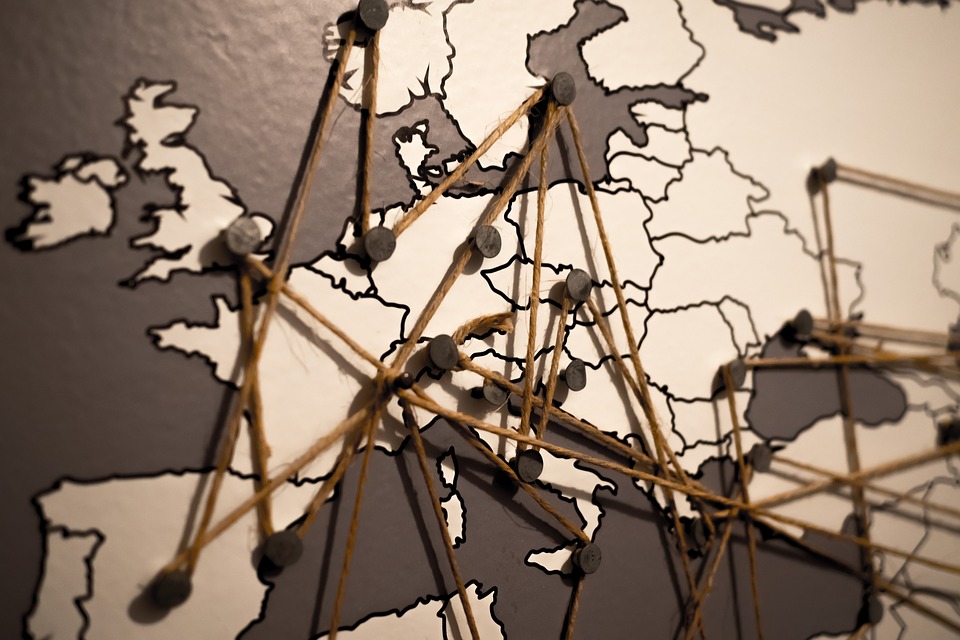 Map of Europe with pins and string between countries to represent connections.