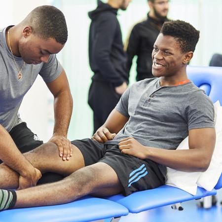 A physiotherapy student massaging the knee of another student