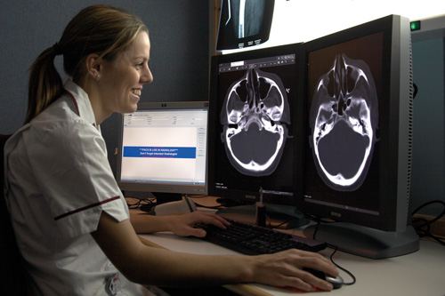 A radiography student evaluating an X-ray on a an LCD computer monitor.