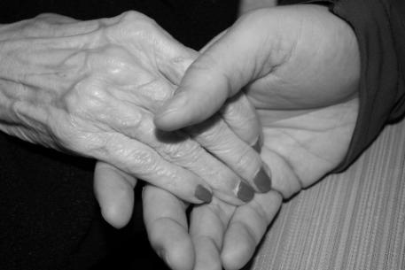 Close-up of an older person's and a younger person's joined hands