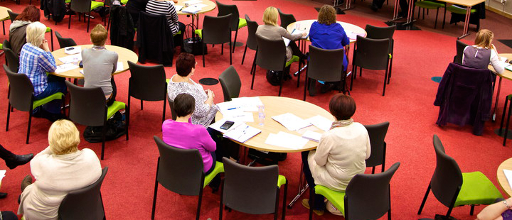 people around tables in a DCM conference