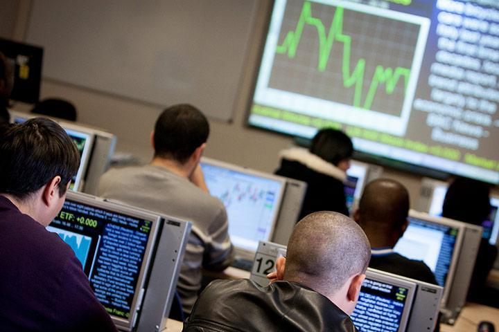 students watching stocks on computer monitors