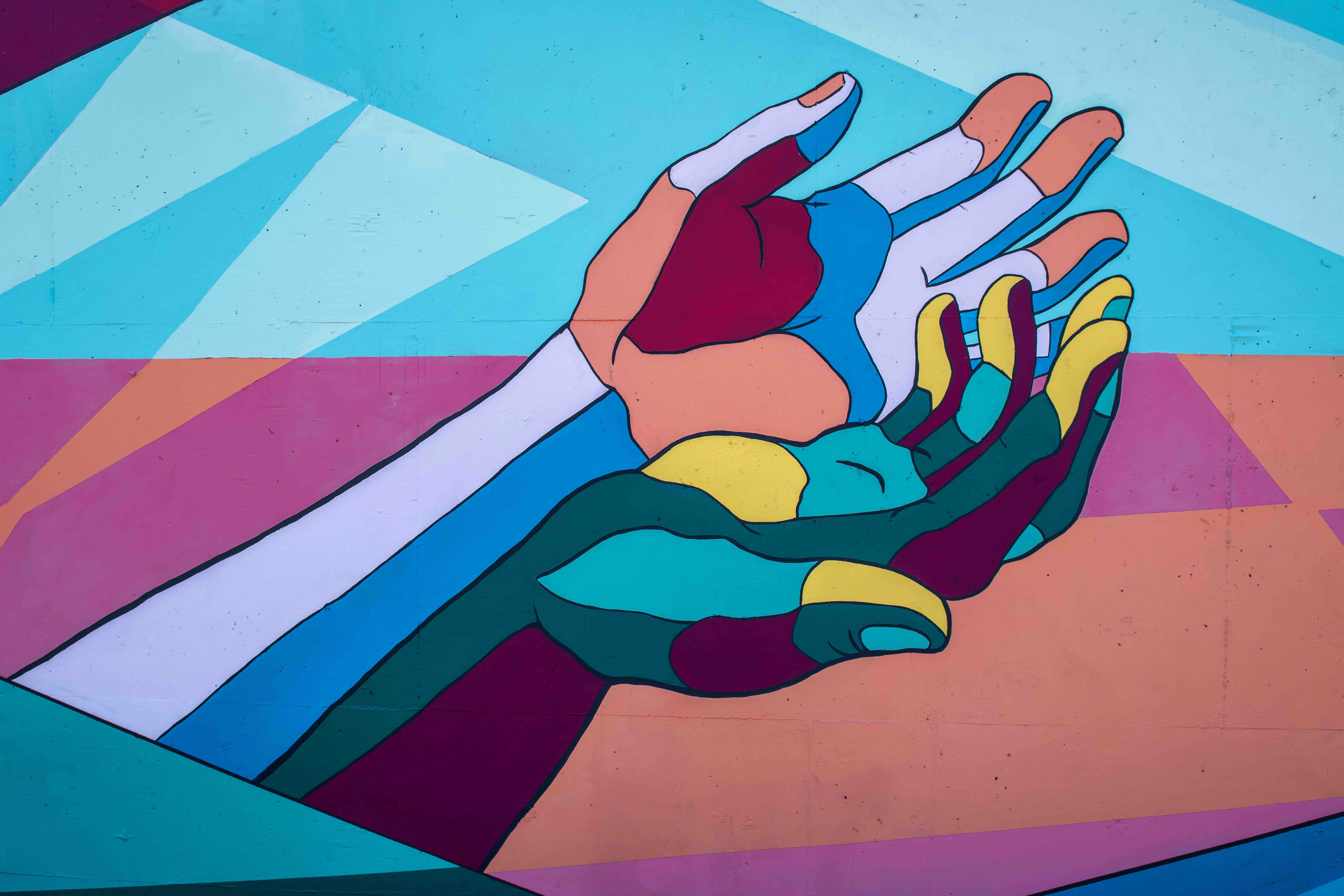 Painting of hands reaching out made of different colours representing equality