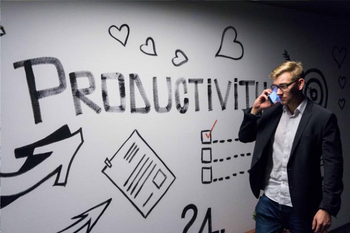 Whiteboard with Productivity written on and entrepreneur on phone