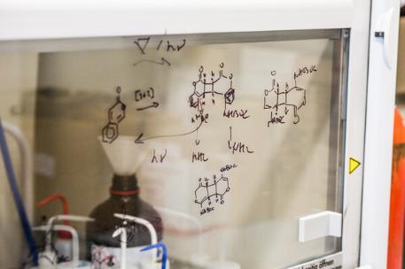 scientific equation written on a clear board in a lab
