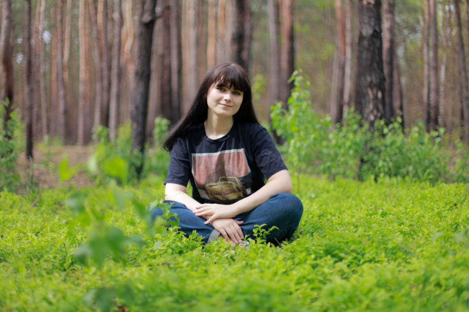 Nika Figat, BA Graphics for Games student, sitting in woodland 