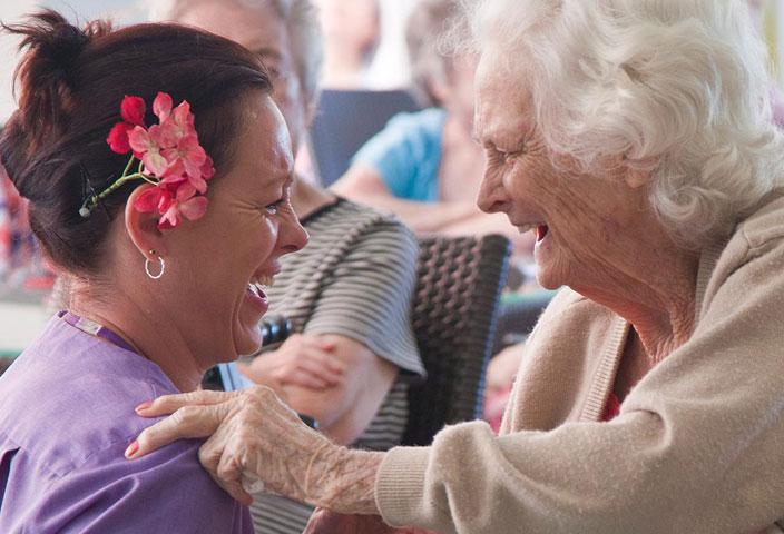 elderly woman and nurse laughing