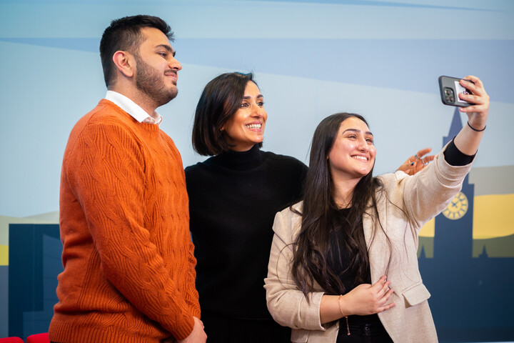 Anita Rani taking a selfie with two students.