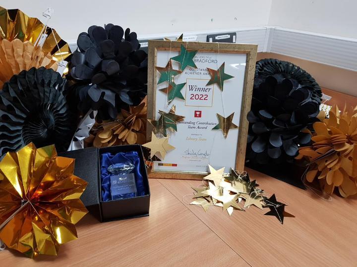Outstanding Contribution Team Award winner's certificate and award surrounded by decorations on a table