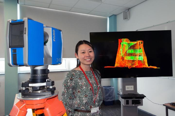 A Faculty of Life Sciences student standing infront of a monitor showing a computer generated image. 