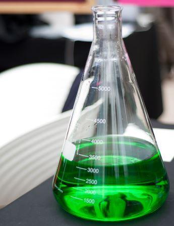 A laboratory jar filled with green liquid