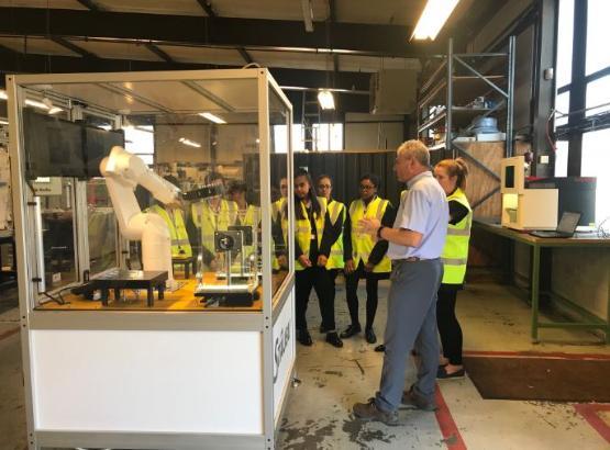 TF Automation MD Tony Hubbert conducts a tour of the factory floor with students pictured in background