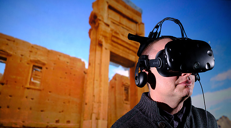 A person wearing a VR headset against a background of an ancient site.