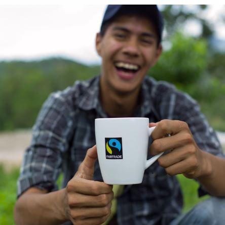 Person holding a mug with the Fairtrade logo on