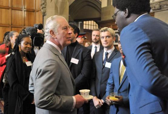 King Charles III shaking the hand of David Owumi