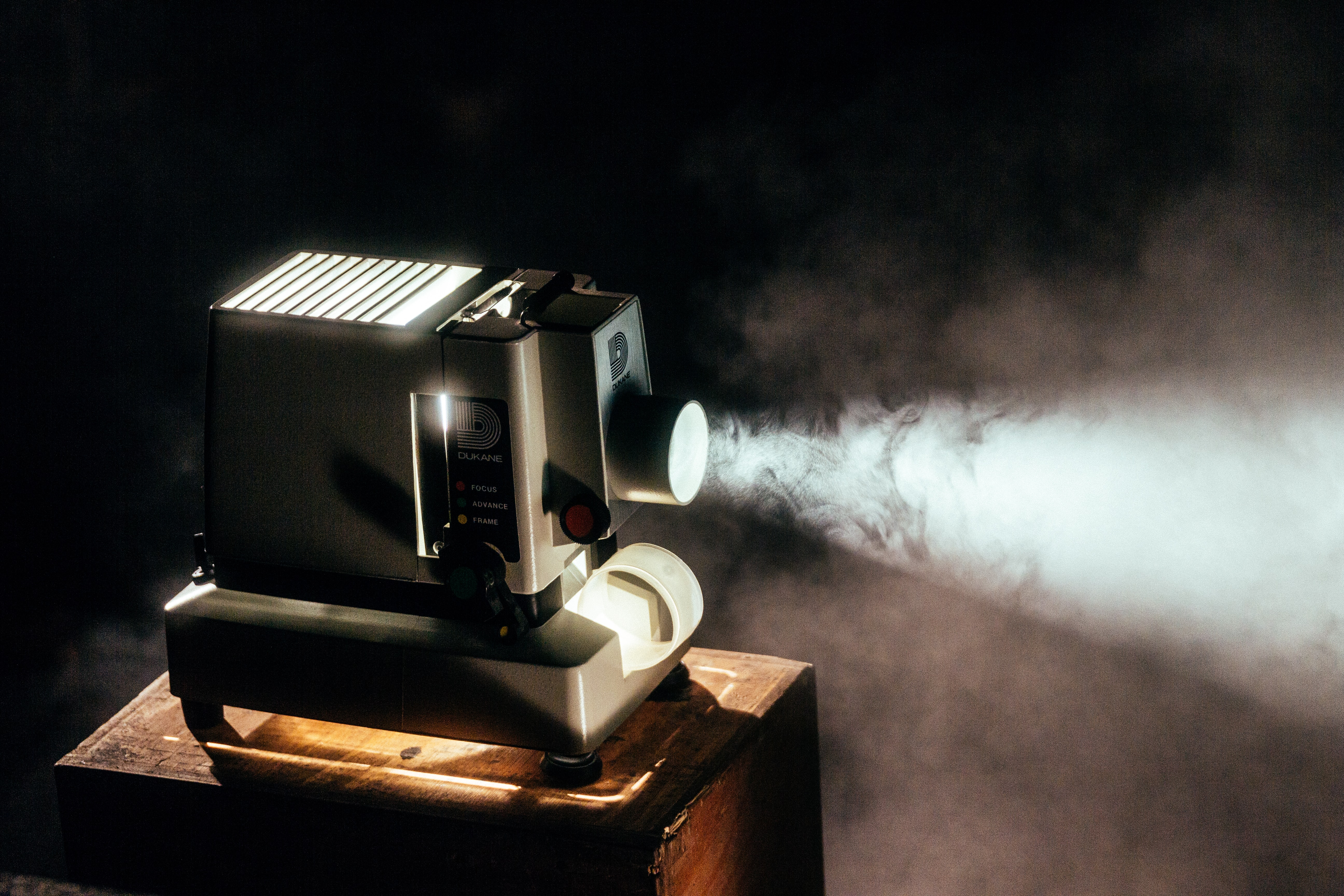 A film projector in a dark room with light being projected