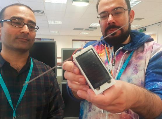 Dr Muhammad Ali and Dr Viktor Doychinov holding a mode pocket cube satellite