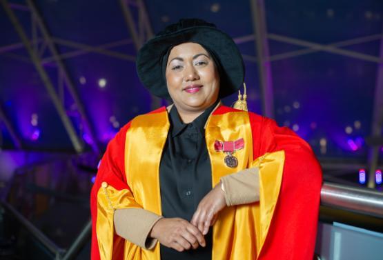 A person in colourful graduation robes
