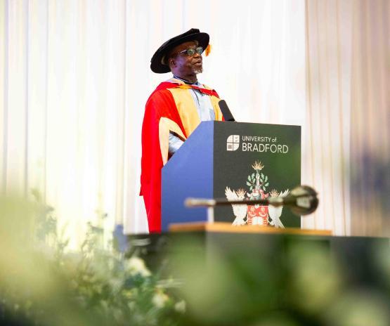 Honorary graduate stands at lectern giving speech