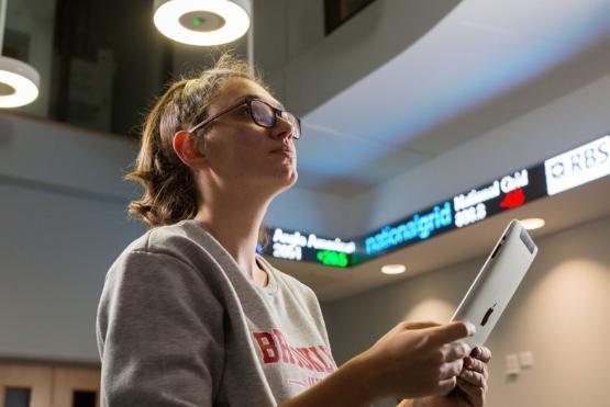 A student looks at a digital tickertape display in the School of Management