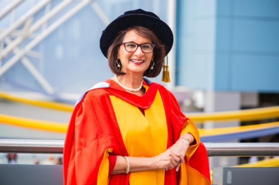 A person wearing red and gold graduation robes