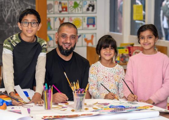 Abdul Ghani painting with his three children