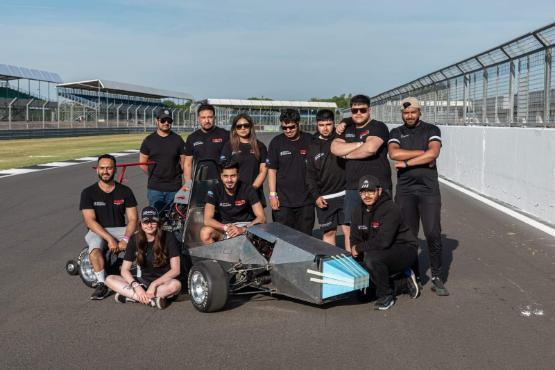 Students with race car on the track at Silverstone in 2022