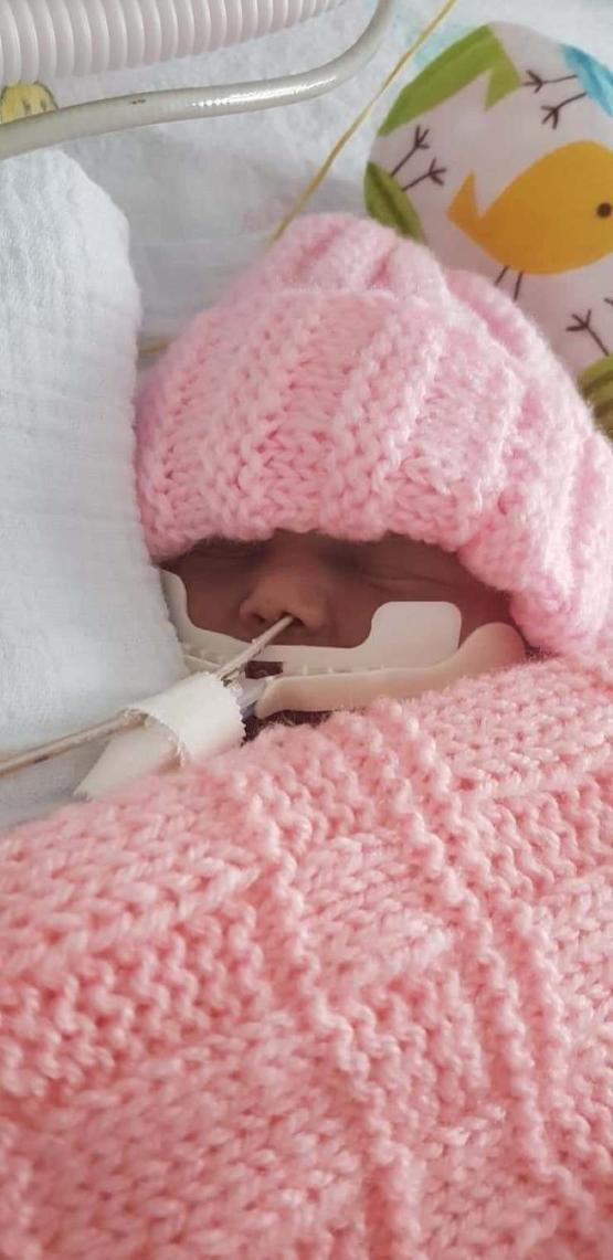 Close up picture of a baby in hospital with woollen hat on