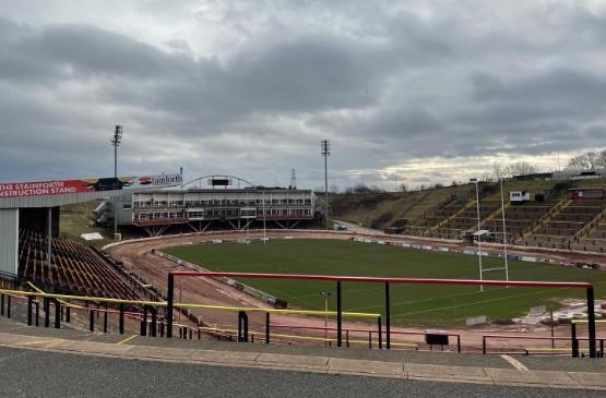 A picture of an empty rugby league stadium which shows some of its stands