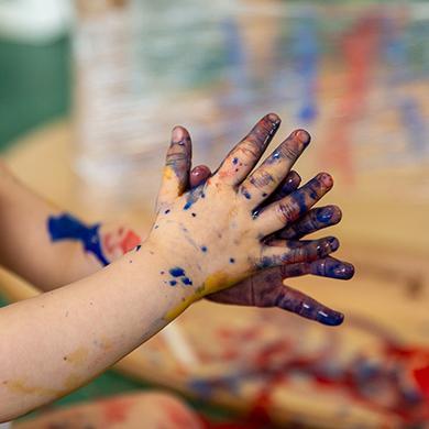 Child playing with paint hands at the nursery