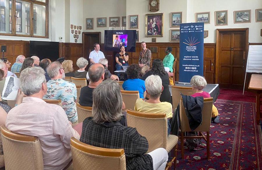 An audience looking towards a panel of speakers at Bradford Literature Festival 2023
