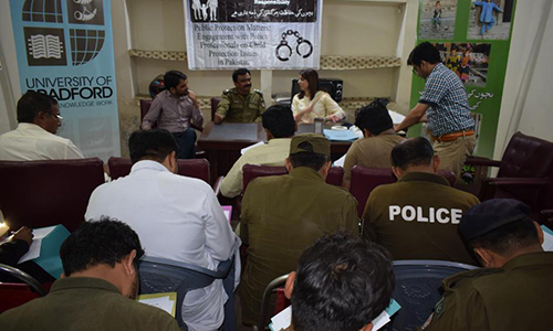 Samina presenting to a group of police in uniform, in Pakistan.