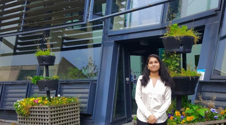 Sneha stood outside the School of Management building.