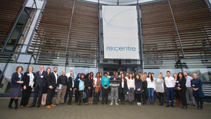A large group of Career Booster Programme participants gathered in front of the University's re:centre building.