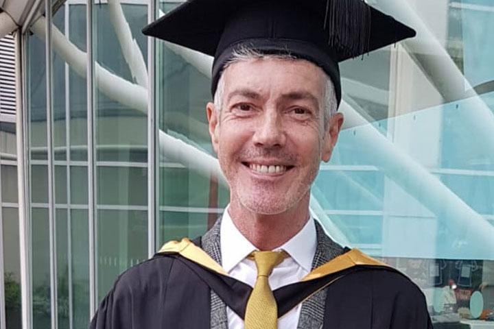 David Bromley, Midwifery graduate profile image in graduation attire
