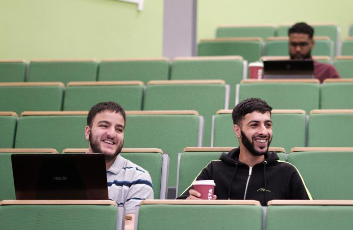 Two male students sat in a lecture theatre.