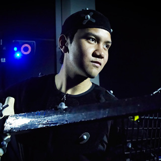 Student wearing mocap outfit in a dark studio.